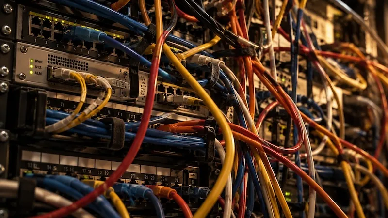 A dense, tangled mass of network cables running across a rack of switches